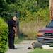 A Washtenaw County Sheriff investigator inspects something on the ground as a deputy looks on in front of a home on Tyler Rd. on Wednesday, August 21, 2013. Melanie Maxwell | AnnArbor.com